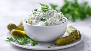 Соус тартар рецепт у білій піалі з великою кількістю зелені.