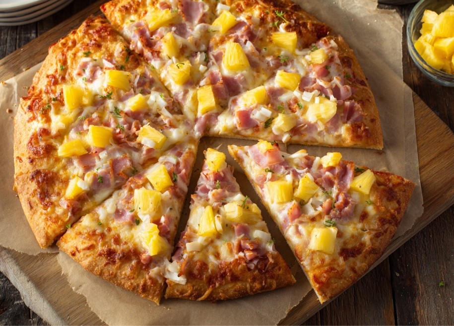 Гавайська піца з ананасами та шинкою на дерев’яній дошці.